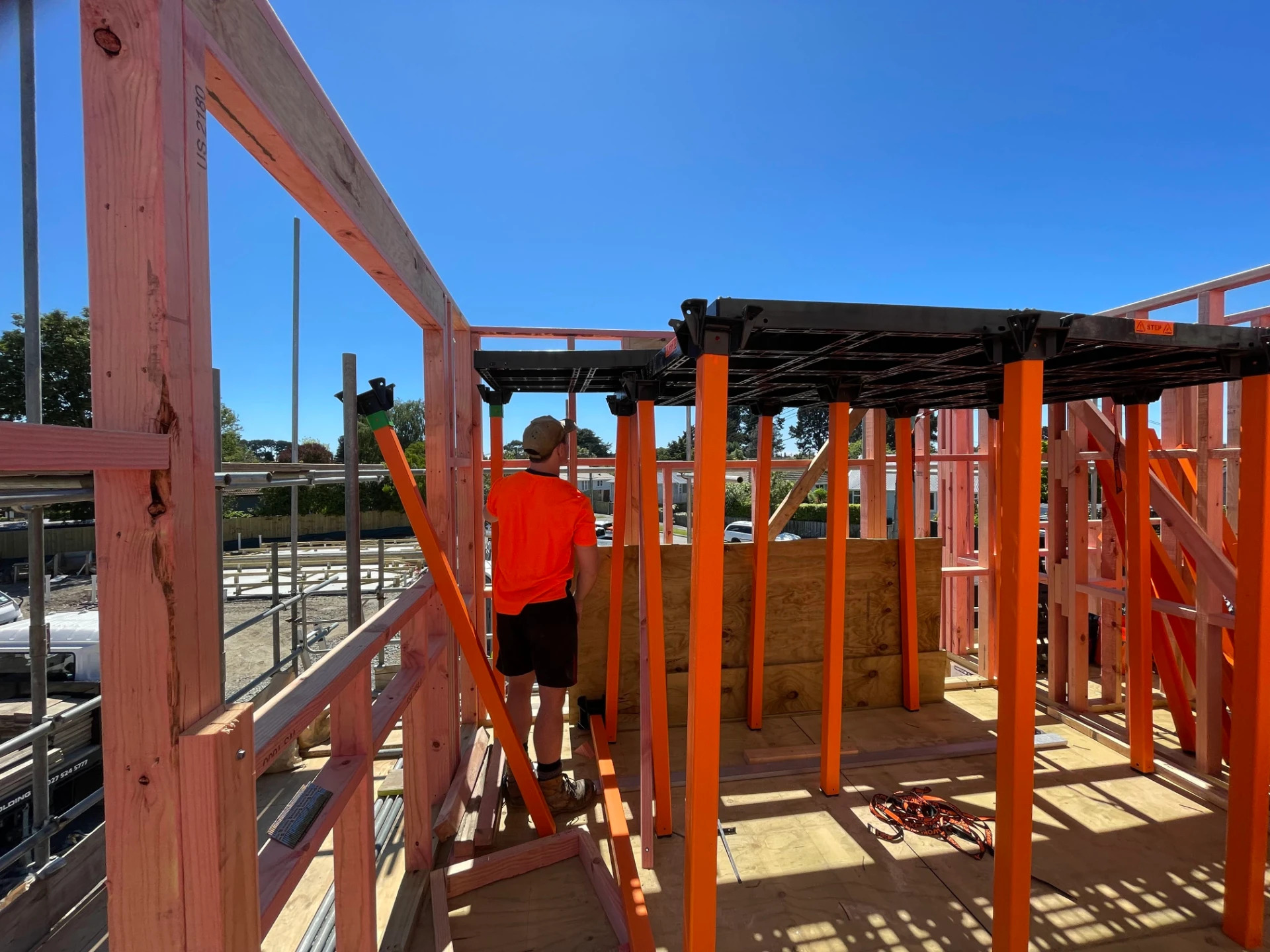 Workdek platform installed inside a timber-framed house with orange legs and black deck panels