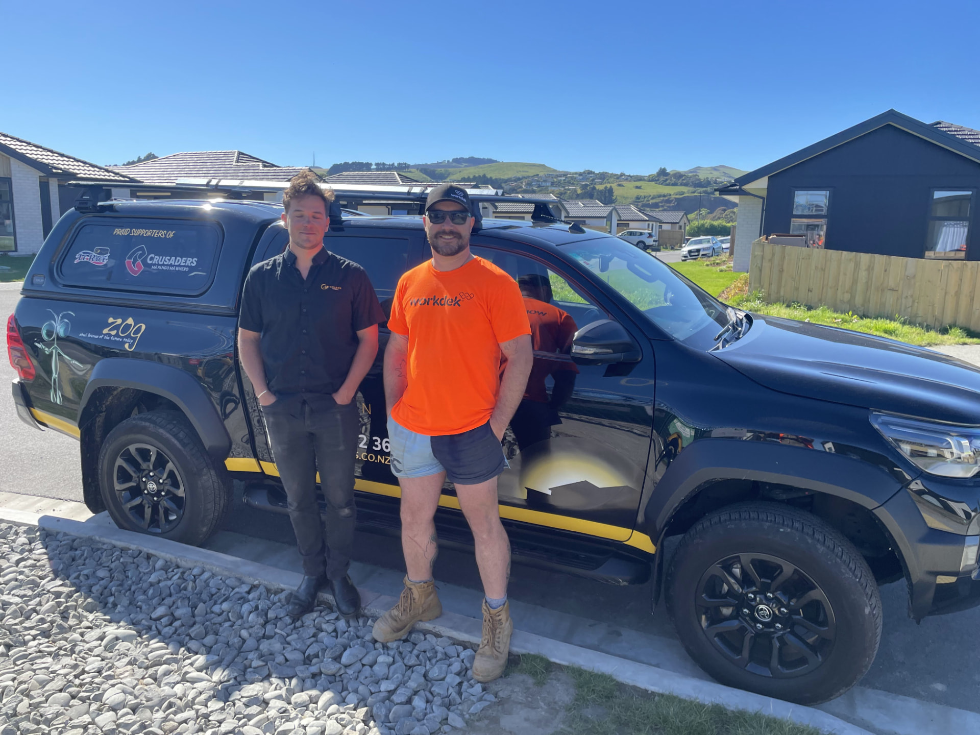 Two of the Workdek team beside the branded ute on a suburban site