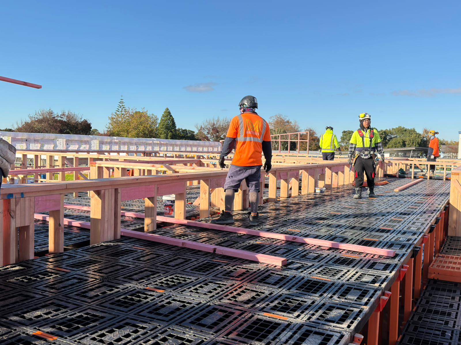 Crew walking across a large Workdek platform spanning a multi-unit timber frame
